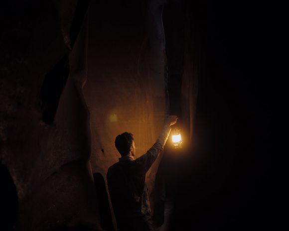 a man holding a lantern in the dark